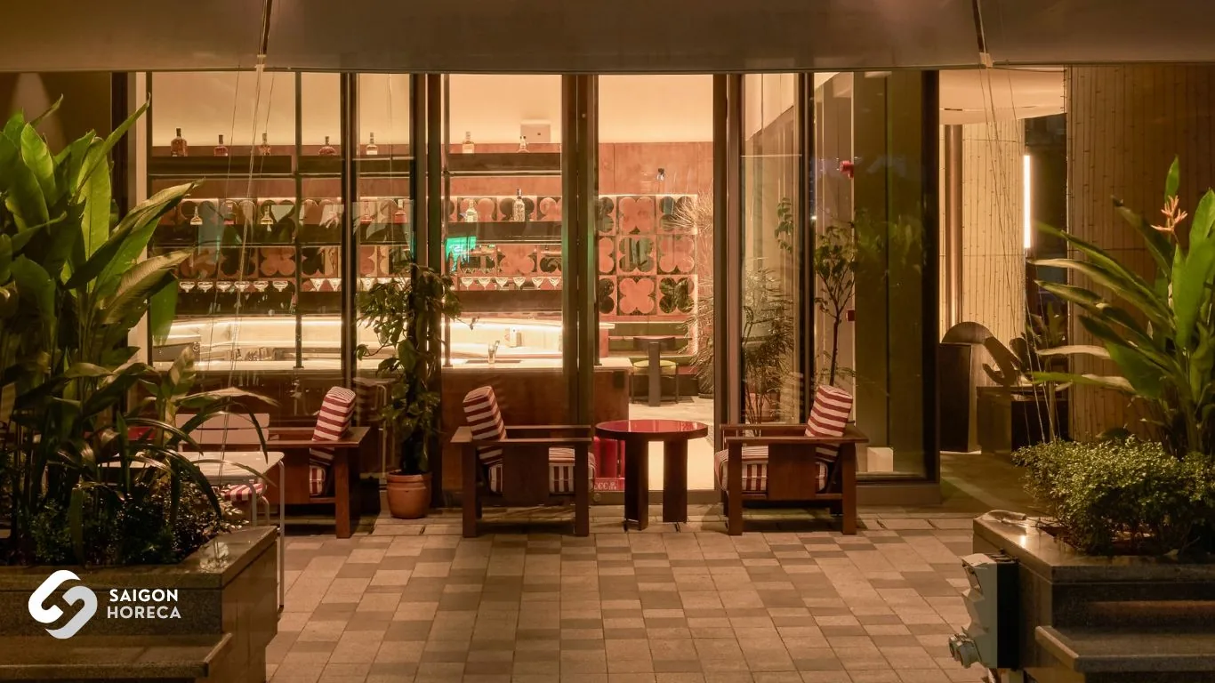 Khu lounge Mâm Mâm với ghế bành nhìn ra quầy bar inox uốn cong nghệ thuật