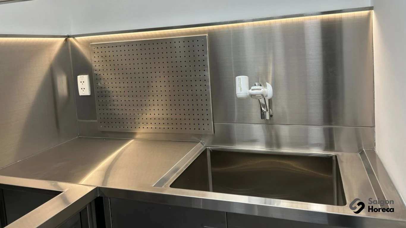 Bồn rửa inox âm bàn tại góc bếp công nghiệp Nichiyo với tấm chắn tường inox đục lỗ và vòi gắn máy lọc nước