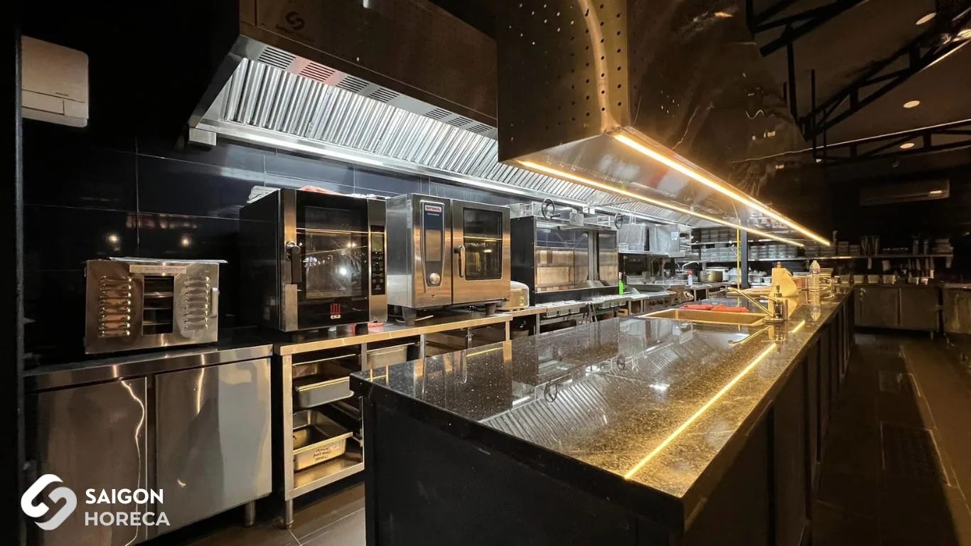 Dây chuyền bếp inox Sol Kitchen & Bar Quận 7 sau cải tạo: lò đối lưu EKA, lò combi RATIONAL, chụp hút inox đèn LED và đảo bếp mặt đá tự nhiên viền LED