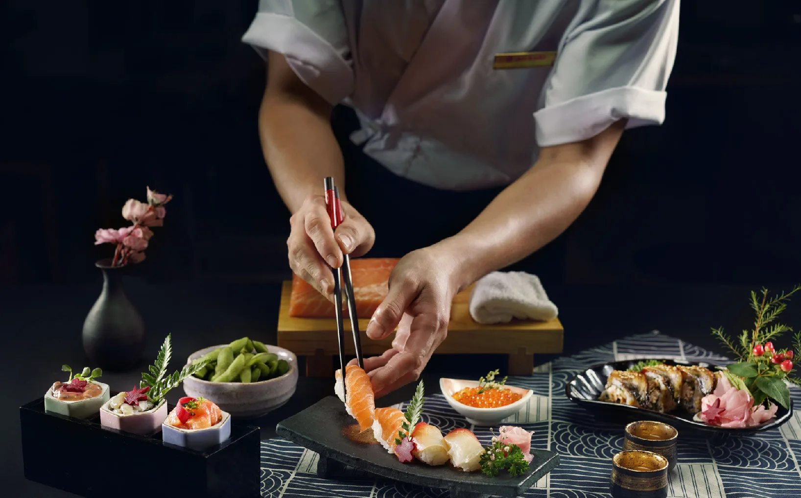 Đầu bếp đặt lát cá hồi lên nigiri trên mâm Omakase Roka Fella